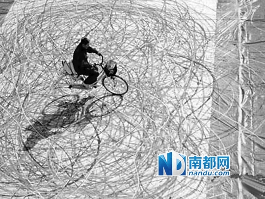 用车轮做画笔在巨大的画布上作画的北野武。