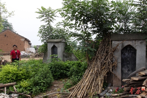 2010年6月16日，河南省南阳市淅川县滔河乡凌岗村移民站在祖坟旁。