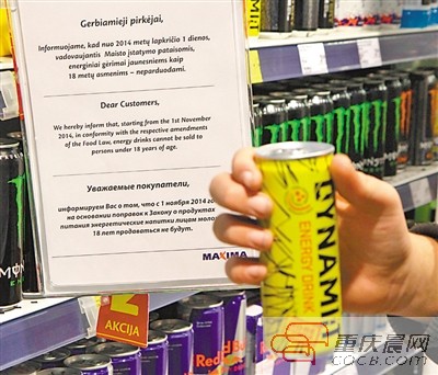 1日，在立陶宛维尔纽斯的一家店铺内，顾客在禁止向未成年人出售能量饮料的告示前展示一罐能量饮料。新华社/法新