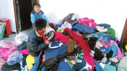 学生在帮忙整理收到的捐赠衣服。(得石中心校供图)