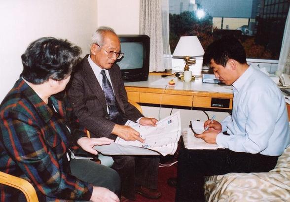 731部队原队员筱冢良雄(中)在接受金成民(右)取证(2000年7月摄)。新华社发