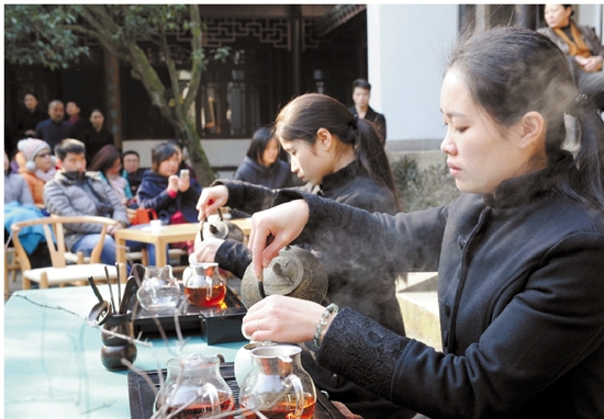 游客正在高档会所变身而来的翠越五韵堂，边喝茶边观看台上古筝、茶道表演。