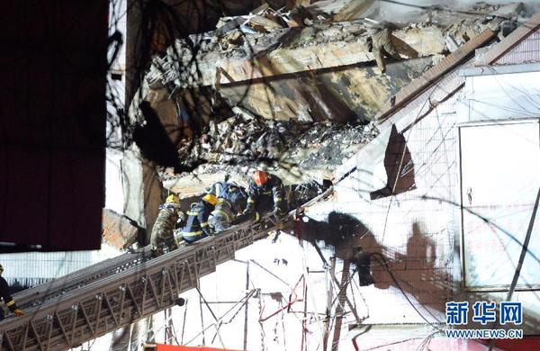 1月2日晚，消防战士在哈尔滨仓库大火现场救出被埋消防战士。新华社记者 王凯 摄