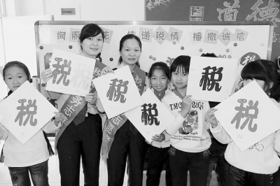 漳浦县地税局女职工走进学校,与孩子们剪税花。