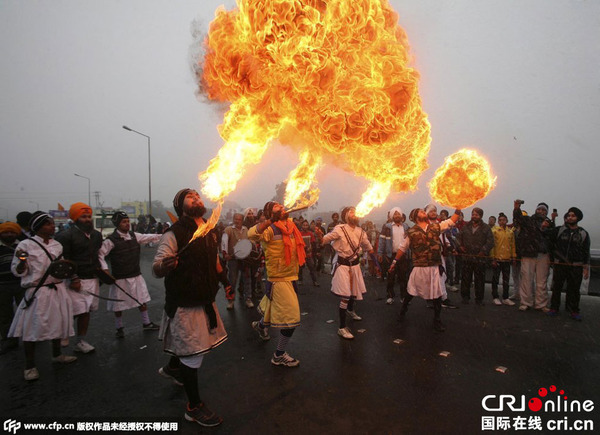当地时间2015年1月5日,印度查谟,当地锡克教徒表演吹火,庆祝古鲁Gobind Singh诞辰。 图片来源:CFP