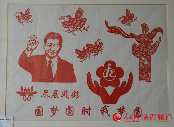 《尽展风彩 国梦圆时我梦圆》刘惠霞作品。展示新一代国家领导人的风采,歌颂团结祥和的社会风气。合手托起的残疾人徽标,预示着全社会对残疾人的关爱、关注和关怀;整体画面显出尽展风彩,国梦圆时我梦圆的美好夙愿。 和冰/摄 前言:刘慧霞,人称白鹿霞子,非物质文化遗产剪纸传承人。祖籍陕西关中腹地白鹿原,襁褓中随父母迁居西安莲湖区,醉心于剪纸艺术,其作品被认为杂糅汉代石刻写意手法,线条舒展、形态优雅。她的剪纸技艺在保留传统民俗剪纸原生态的基础上形成自己独立的艺术风格。她在西安市莲湖区残联兴办剪纸艺术工作室,倾囊相授