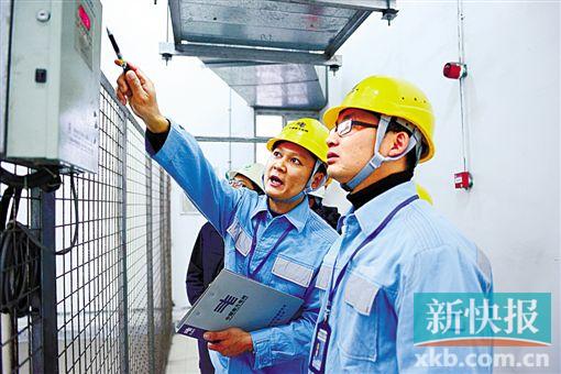 ▲ 东莞供电局人员检查中储粮变压器温度。 袁绮雯/摄