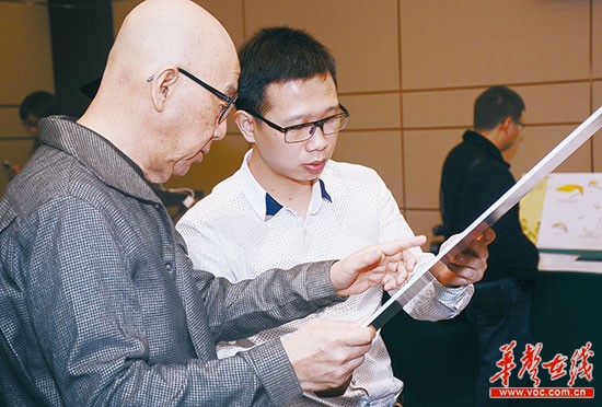 周政安(右)与投资人杨华强仔细研究眼镜设计稿。通讯员 摄