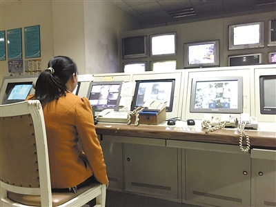 ▲金沙港湾B区监控，刘大姐正在值班。记者按下12号楼2号梯的紧急呼叫按钮，中间那部对应话机（红圈）就会响起。 ?电梯面板上的“警铃”（左）与“紧急通话”（右）按钮。重庆晨报记者 卢雨 摄