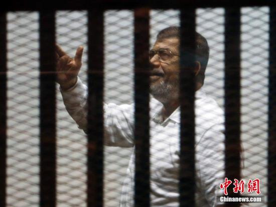 当地时间2014年11月18日，埃及开罗，埃及前总统穆尔西和其他穆兄会成员一起出庭受审。图片来源：CFP视觉中国