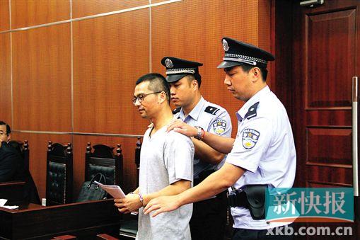 ■何继雄由两名法警押着进入法庭。新快报记者张国锋/摄