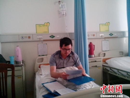 杜志勇在病房一边打针一边查看患者病历杨添龙摄
