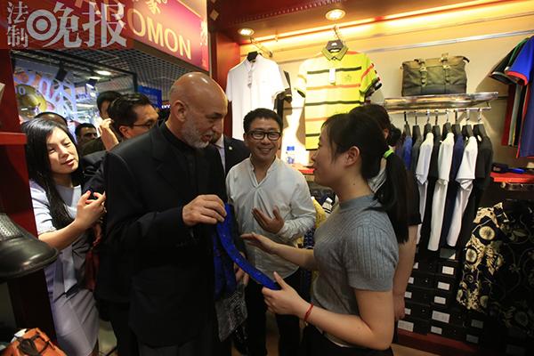 5月26日下午，阿富汗前总统卡尔扎伊来到秀水街购物，图为他在一家商店选购领带。（图片来源：《法制晚报》）