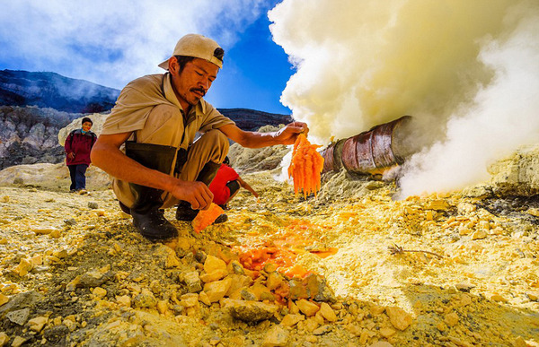 收集固化硫磺的矿工正在印尼东爪哇省的伊真火山坑中处理矿物。（网页截图）