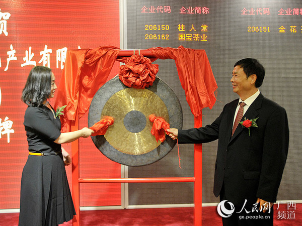 防城区区委书记莫小林与桂人堂集团副总裁王婷为桂人堂挂牌上市敲锣