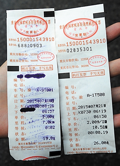乘客展示的两张同车程不同价格的出租车票。 重庆晨报记 李斌 摄