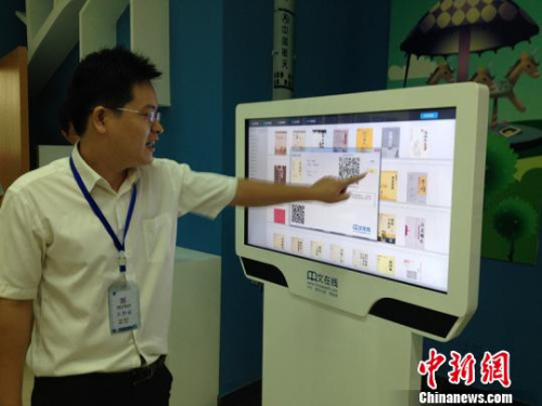 图为潍坊市图书馆里工作人员正在为大家演示如何用触屏机阅读儒学典籍。　曾洁 摄