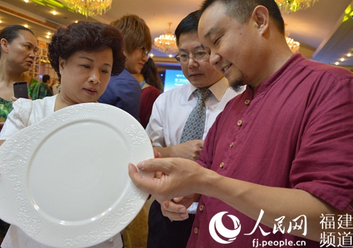 德化县县长欧阳秋虹(左一)与白瓷艺术家陈仁海(右一)共同鉴赏厦门-阿姆斯特丹航班专用白瓷艺术品 李挺摄