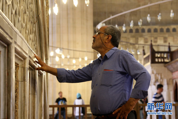 一位男士在欣赏清真寺内墙上的手工雕刻和纹饰，塞利米耶清真寺内雕刻工艺十分精美。