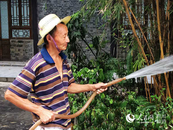 持续高温天气下，为树苗降温的园艺工人。（朱虹 摄）