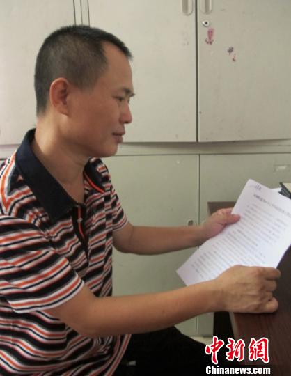 圖為薛根軍在傢裡看工作文件。　付美斌　攝