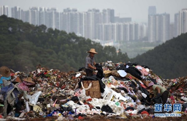 　　一名拾荒者在南宁市城南垃圾填埋场捡拾垃圾（8月14日摄）。