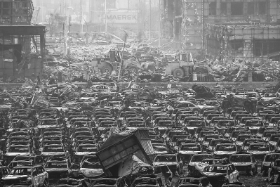 17日，救援人员在爆炸现场使用工程机械清除障碍。