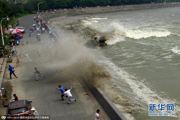 　　    2015年08月29日，杭州，农历七月十六，钱塘江秋季潮汛再起。钱江潮在杭州下沙一处江堤翻卷上岸，扑向观潮的人群，吓得观潮客四散奔逃。图片来源：cfp