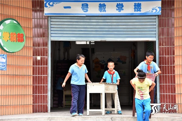 学生将教室多余课桌搬进地下室。