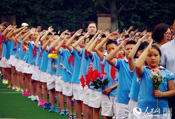 四川大学附属实验小学西区,升旗仪式时,少先队员敬礼唱国歌。(王军 摄)