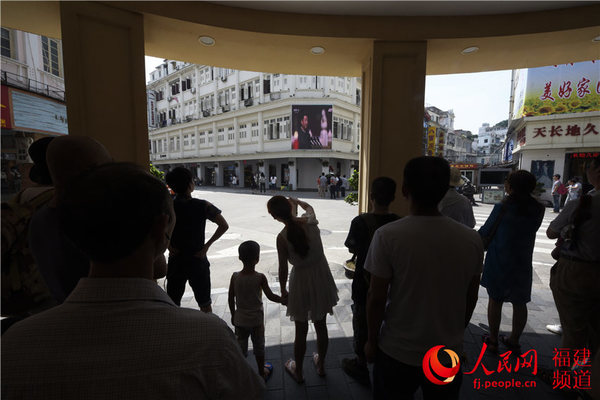 市民游客驻足闽南骑楼前观看胜利日大阅兵直播。沈宇波 摄