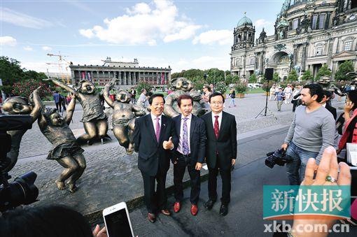 ■中国驻德大使馆公使衔参赞韩光明(左)在《欢乐大地》雕像前竖起大拇指。