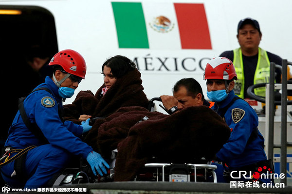 当地时间2015年9月18日,墨西哥墨西哥城,在埃及军警错杀墨西哥游客事件中幸存的墨西哥游客乘坐总统专机抵达,身上盖着墨西哥国旗被送往医院。图片来源:CFP