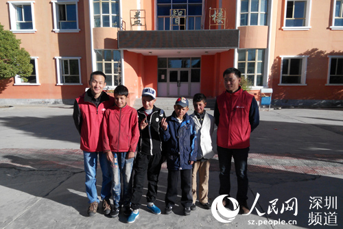 支教老师王海、文联民与塔县中学学生合影。（陈育柱 摄）