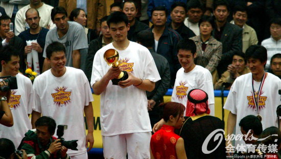 2003年哈尔滨亚锦赛，中国男篮获得冠军。图片背景：2003年10月1，2003年男篮亚锦赛决赛，中国106：96胜韩国。中国队上台领奖姚明接过冠军奖杯