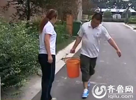 在淄博市高新区通乾拉菲小区小区内，居民忙着提水。（视频截图）