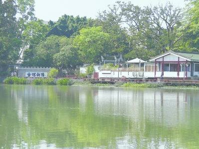 福州西湖“古堞斜阳”景点，绿树、碧水和灰白相间的仿古茶楼构成和谐悦目的画面。