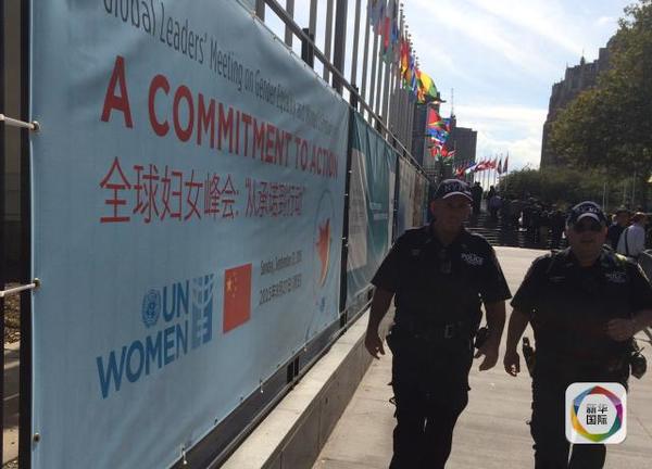 两名警察从联合国系列峰会展板前走过。（新华社记者李忠发摄）