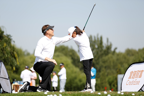 小学员在教练的指导下学习高尔夫