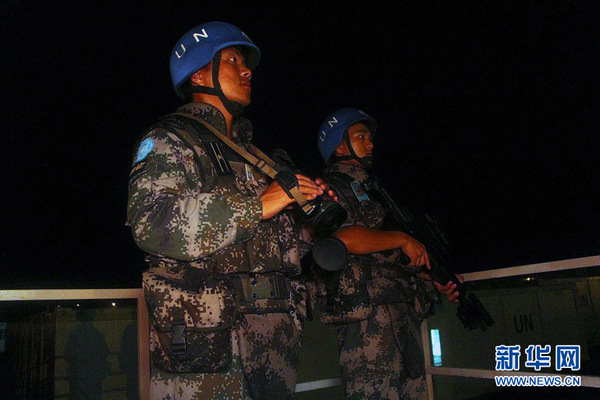 中秋之夜，我国首支赴南苏丹维和步兵营官兵仍坚守岗位值守和平，图为维和步兵营干部替战士站岗。孟伟建摄