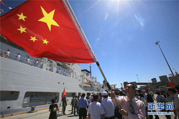 10月7日,一名华人挥动五星红旗迎接中国和平方舟医院船访问澳大利亚布里斯班港。江山 摄