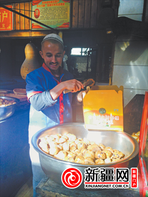 22 日，木太力甫·吾甫尓正在为顾客打包“袖珍馕”。（记者郝玉摄）