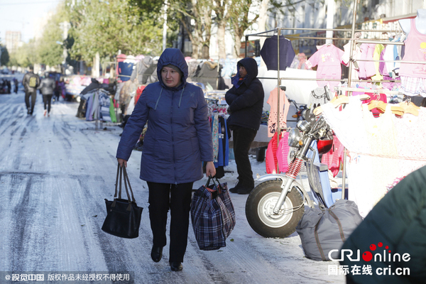 　　2015年10月24日，黑龙江黑河，俄罗斯大妈组团乘坐两辆中巴赴黑河扫货购物。 一位俄罗斯游客拎着购买的一大包商品。图片来源：cfp