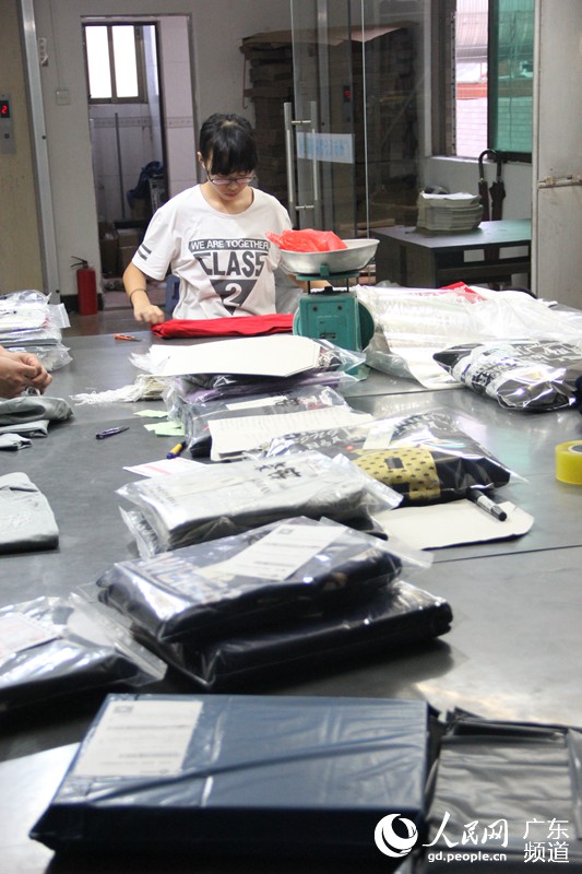 在工作间里，工人们熟练地摆弄着各式货物。每件货物都要经历验货、打单、包装、贴单、出货等步骤。钟哲 摄