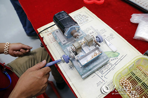 展会现场参展商现场为珍珠钻孔，制作项链