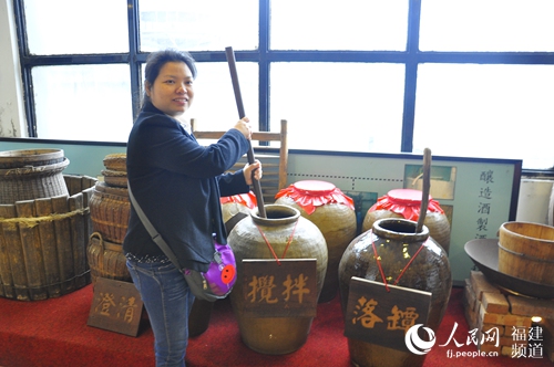 位于马祖岛上的马祖酒厂展示了马祖老酒酿造工艺，图为游客体验搅拌老酒工序。 吴隆重 摄