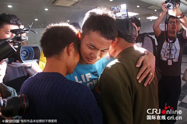 2015年11月11日,深圳市刑侦局,被拐的林某(中)与亲人紧紧拥抱在一起,泪如雨下,十分激动。 图片来源:刘有志/视觉中国