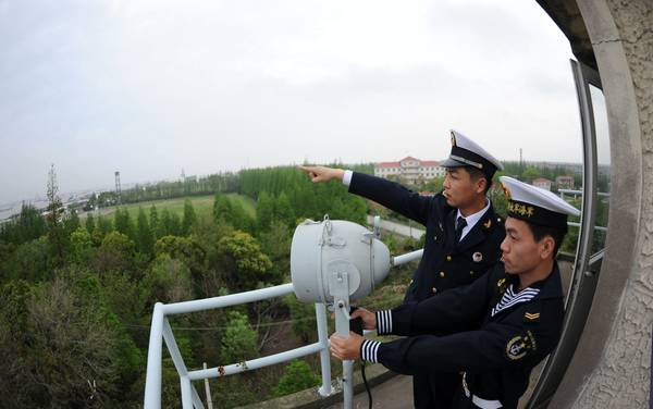 长江口的一个孤岛上，陈昌健与上等兵庄水波在为过往的舰艇发灯光信号。