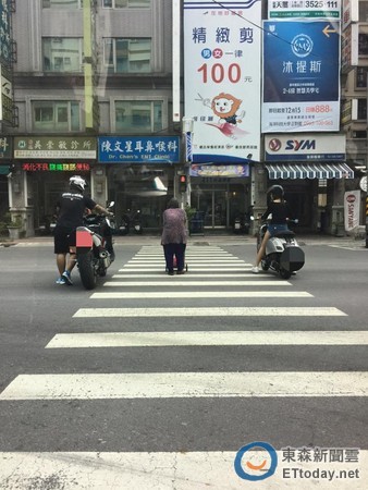 ▲骑士在老奶奶身旁挡车。(图/台湾“东森新闻”)