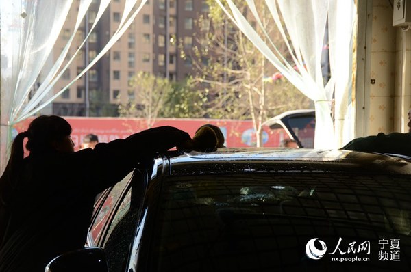 擦拭车顶的琪琪。